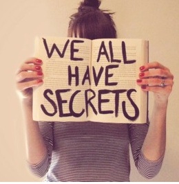 photo of woman holding sign "we all have secrets"