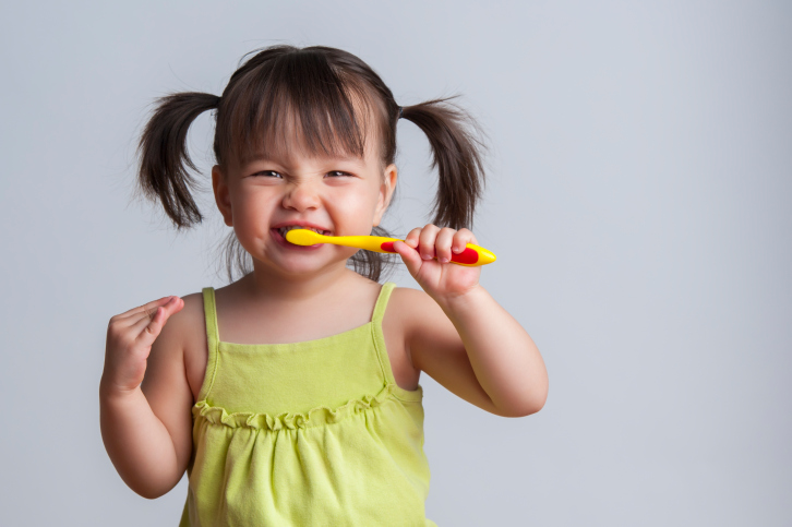 photo of little girl brushing her teeth